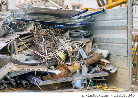 Heap of scrap metal, cables and construction debris in a container, highlighting recycling, demolition waste and industrial materials disposal process Heap of scrap metal, cables and construction debris in a container, highlighting recycling, demolition waste and industrial materials disposal process 138195340
