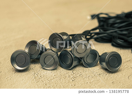 Grey parking sensors with wires on the concrete surface Grey parking sensors with wires on the concrete surface 138195778
