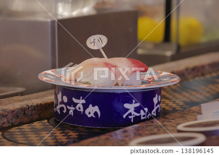 Yellowtail nigiri sushi spinning on a rotating race track Yellowtail nigiri sushi spinning on a rotating race track 138196145