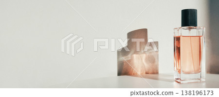 Glass perfume bottle standing on white surface with shadow, banner format 138196173