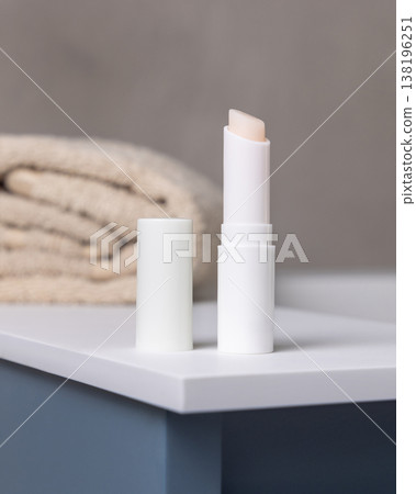 Blank lip balm stick mockup with cap near bath towel in beige bathroom. Unbranded cosmetic packaging Blank lip balm stick mockup with cap near bath towel in beige bathroom. Unbranded cosmetic packaging 138196251