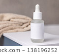 Dropper bottle with blank label near bath towels in beige bathroom, cosmetic mockup 138196252