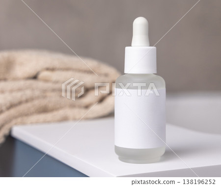 Dropper bottle with blank label near bath towels in beige bathroom, cosmetic mockup Dropper bottle with blank label near bath towels in beige bathroom, cosmetic mockup 138196252
