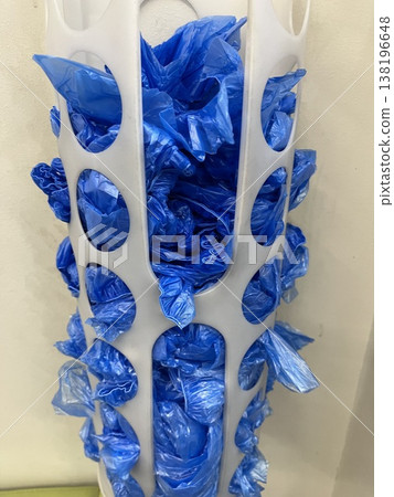 Blue shoe covers stored in a white container in a room with a simple setup Blue shoe covers stored in a white container in a room with a simple setup 138196648