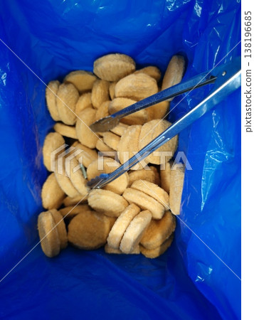 Food items placed in a blue container with metal tongs for serving Food items placed in a blue container with metal tongs for serving 138196685