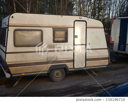 Old caravan parked by the roadside near trees during late afternoon in autumn Old caravan parked by the roadside near trees during late afternoon in autumn 138196718