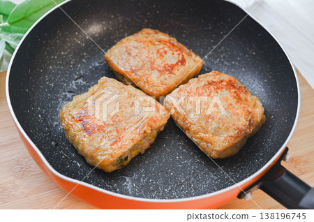 Deep-fried tofu stuffed with ground pork and vegetables is pan-fried. 138196745
