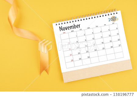 November 2027 desk calendar with yellow ribbon on yellow color background. 138196777