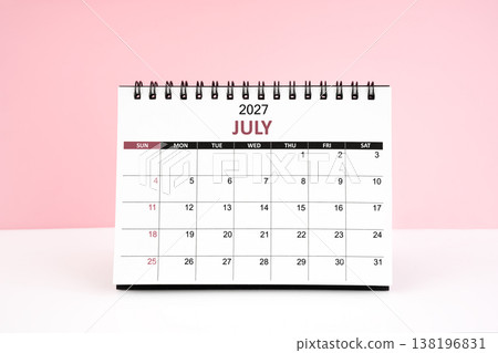 July 2027 desk calendar on white table with pink background. July 2027 desk calendar on white table with pink background. 138196831