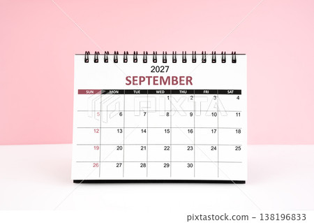 September 2027 desk calendar on white table with pink background. 138196833