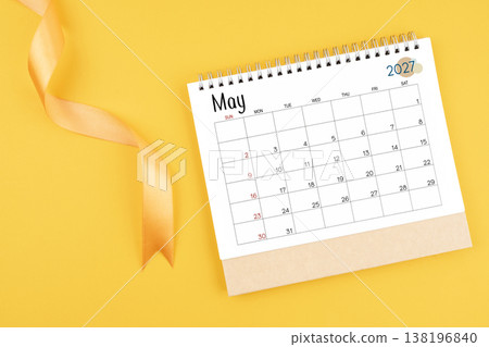 May 2027 desk calendar with yellow ribbon on yellow color background. May 2027 desk calendar with yellow ribbon on yellow color background. 138196840