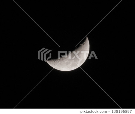 Crescent Moon shines brightly in a dark night sky revealing its detailed surface texture 138196897