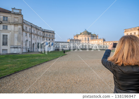 Stupinigi, turin, italy. March 23,2026. Woman holding a smartphone, capturing a beautiful view of the historic palazzina di caccia di stupinigi on a clear day Stupinigi, turin, italy. March 23,2026. Woman holding a smartphone, capturing a beautiful view of the historic palazzina di caccia di stupinigi on a clear day 138196947