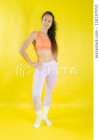 Fit woman posing in sportswear on yellow background Fit woman posing in sportswear on yellow background 138197055