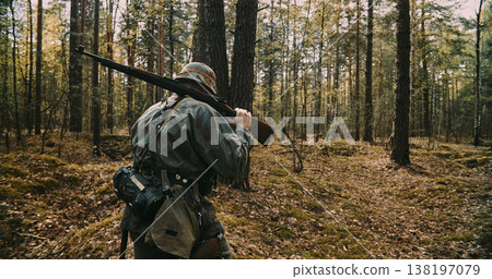 Rear view of German soldier walking into forest with rifle during WWII Rear view of German soldier walking into forest with rifle during WWII 138197079