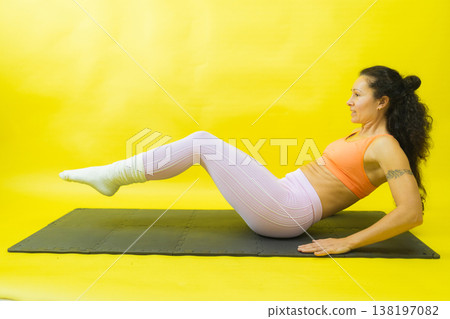 Woman exercising abs on mat maintaining balance 138197082
