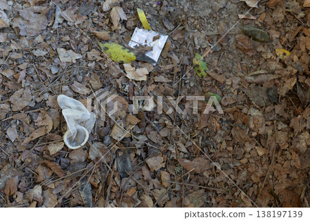 Used condom and wrapper littering forest floor Used condom and wrapper littering forest floor 138197139