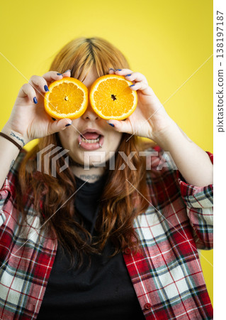 Young person holding orange halves creating funny eyes Young person holding orange halves creating funny eyes 138197187