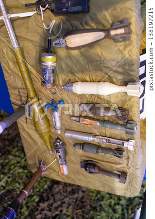Displaying various unexploded ordnance and explosive weapons on a tarp 138197215