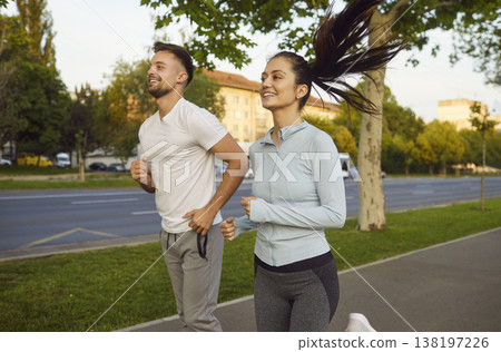 Morning run of happy couple of runners on city road, healthy physical exercise and cardio training Morning run of happy couple of runners on city road, healthy physical exercise and cardio training 138197226