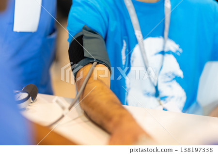 Person checking blood pressure with sphygmomanometer Person checking blood pressure with sphygmomanometer 138197338