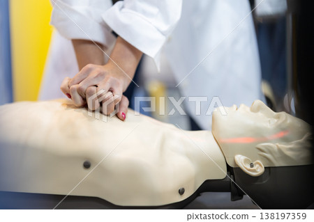 Hands pressing chest on cpr mannequin during first aid training Hands pressing chest on cpr mannequin during first aid training 138197359