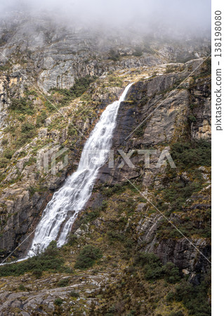 Waterfall cascading from snowy mountains on the Laguna 69 trek, Peru 138198080