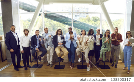 Group of business people standing in office looking cheerful at the camera and smiling. 138200317