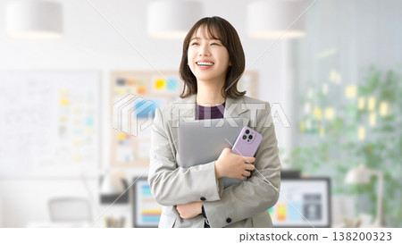 Smiling woman/businesswoman holding a computer and smartphone 138200323