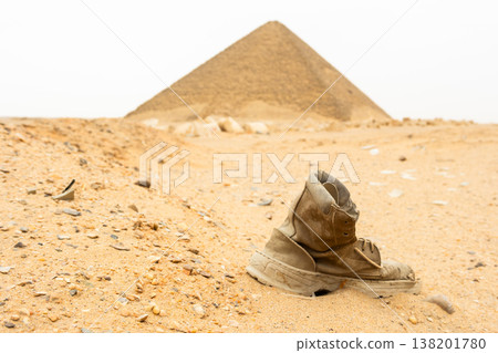 Red pyramid located in Dahshur, Egypt. The pyramid is surrounded by sandy terrain and rocky formations, showcasing ancient Egyptian architecture. 138201780