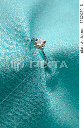 Close-up of diamond ring on teal silk Close-up of diamond ring on teal silk 138202048