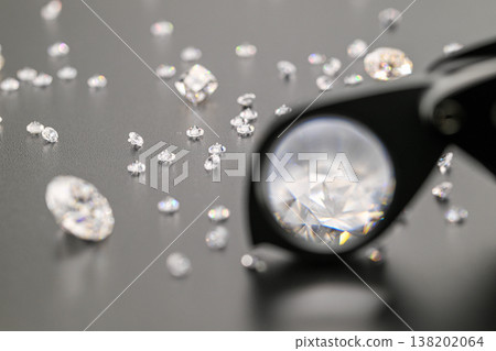 Magnifying glass highlights single diamond among scattered crystals Magnifying glass highlights single diamond among scattered crystals 138202064
