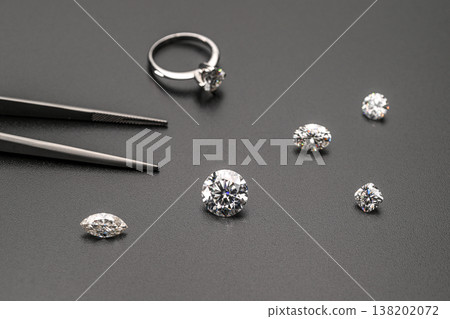 Professional jeweler tools with sparkling diamonds on textured black background Professional jeweler tools with sparkling diamonds on textured black background 138202072