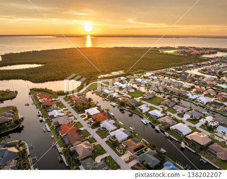 Evening glow over Punta Gorda, Florida. Waterfront with luxurious houses, palm trees and peaceful suburban atmosphere. Evening glow over Punta Gorda, Florida. Waterfront with luxurious houses, palm trees and peaceful suburban atmosphere. 138202207