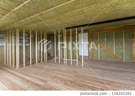 Construction and renovation of big spacious empty unfinished attic room with oak floor, walls and ceiling insulated with rock wool and fiber glass for cold barrier and wooden frame for future walls. Construction and renovation of big spacious empty unfinished attic room with oak floor, walls and ceiling insulated with rock wool and fiber glass for cold barrier and wooden frame for future walls. 138202261