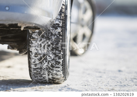 Close-up of car wheels rubber tire in deep snow. Transportation and safety concept. Close-up of car wheels rubber tire in deep snow. Transportation and safety concept. 138202619