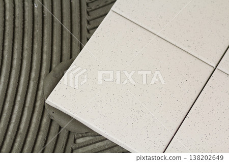Ceramic tiles and tools for tiler. Floor tiles installation. Home improvement, renovation - ceramic tile floor adhesive Ceramic tiles and tools for tiler. Floor tiles installation. Home improvement, renovation - ceramic tile floor adhesive 138202649