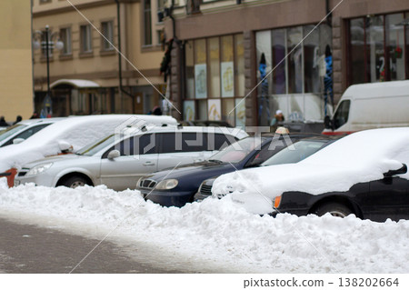 Cars parked on a side of city street covered with snow in winter. Cars parked on a side of city street covered with snow in winter. 138202664
