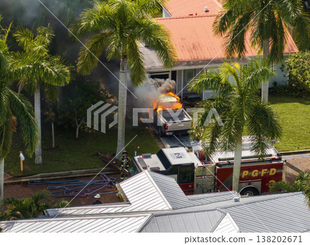 Car on fire in Florida after hurricane flooding caused electrical short circuit. Firefighters extinguishing burning vehicle 138202671