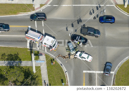 Car crash site with emergency services personnel and vehicles responding to accident on American street. First responders helping victims of vehicle collision on road in USA 138202672