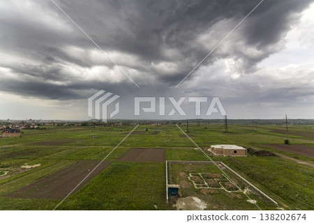 Building site in green field. Trenches dug in ground and filled with cement as foundation for future house on background of distant town under cloudy sky. Construction and real property concept. Building site in green field. Trenches dug in ground and filled with cement as foundation for future house on background of distant town under cloudy sky. Construction and real property concept. 138202674