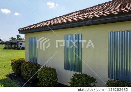Boarded windows with storm shutters for hurricane protection of Florida home. Protective measures before natural disaster Boarded windows with storm shutters for hurricane protection of Florida home. Protective measures before natural disaster 138202685