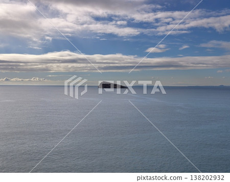 Sea view scene, Broad ocean panorama featuring remote small island and multitiered cloud formations Sea view scene, Broad ocean panorama featuring remote small island and multitiered cloud formations 138202932
