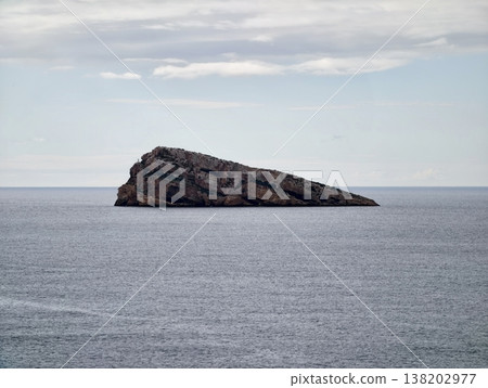Calm ocean backdrop with textured rugged rocks displaying layered erosion patterns for educational purposes Calm ocean backdrop with textured rugged rocks displaying layered erosion patterns for educational purposes 138202977