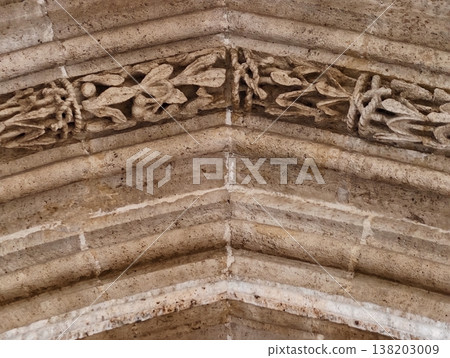 Image of aged arch, Photograph depicting old limestone arch with elaborate foliage engravings and textures Image of aged arch, Photograph depicting old limestone arch with elaborate foliage engravings and textures 138203009