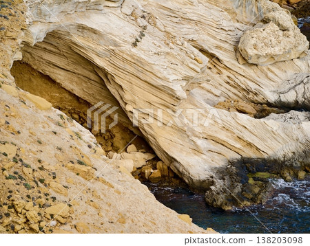 An isolated seaside shelter carved into rocky cliffs providing calm sanctuary and exploration options 138203098