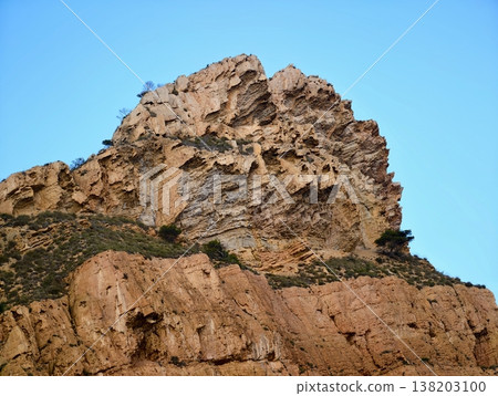 Intimate photograph of coarse grained limestone displaying stratified weathered surface in sunlight 138203100