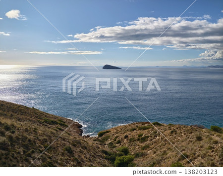 Bright seaside scene with tranquil waters, Luminous coastal inlet opening to serene blue ocean 138203123