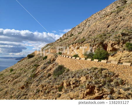 Golden glow over rugged trail, Path along cliff illuminated by warm sunlight and scenic surroundings Golden glow over rugged trail, Path along cliff illuminated by warm sunlight and scenic surroundings 138203127