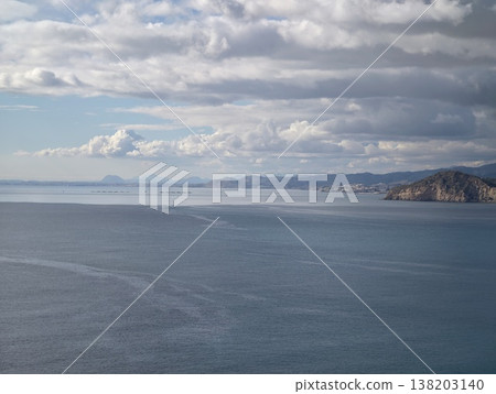 Wide open ocean beneath cloudy sky emphasizing calming waves and pristine shoreline preservation Wide open ocean beneath cloudy sky emphasizing calming waves and pristine shoreline preservation 138203140
